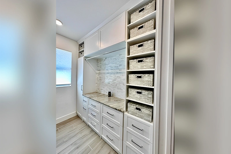 A modern laundry room with stacked storage baskets and a countertop.