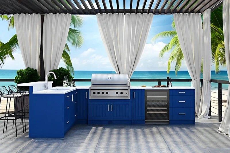 Outdoor kitchen with blue cabinets and ocean view.