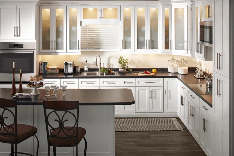 Bright kitchen with white cabinets and a wooden chair.