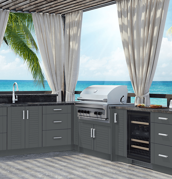 Modern outdoor kitchen with grill and ocean view.