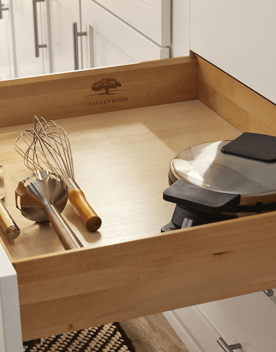 A wooden tray with kitchen utensils and a grill pan.