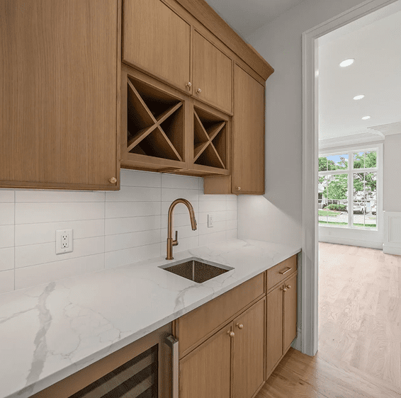 Modern kitchen with wooden cabinets and marble countertop.