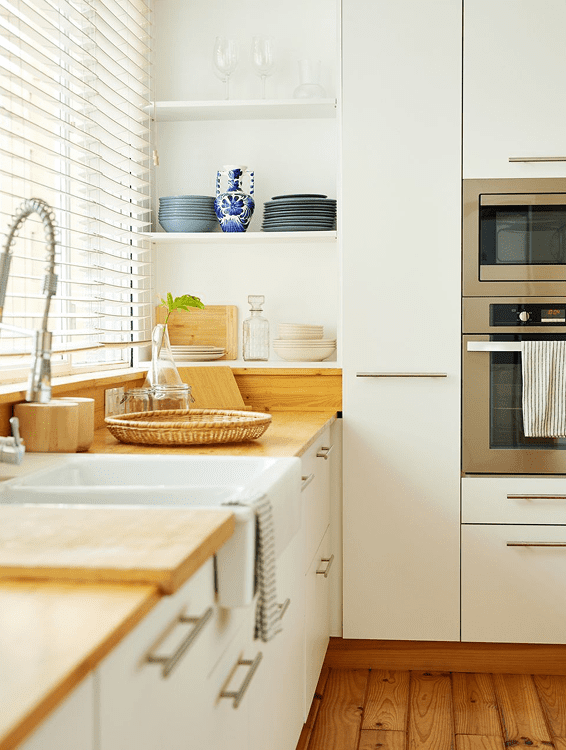 Bright kitchen with wooden countertop and modern appliances.