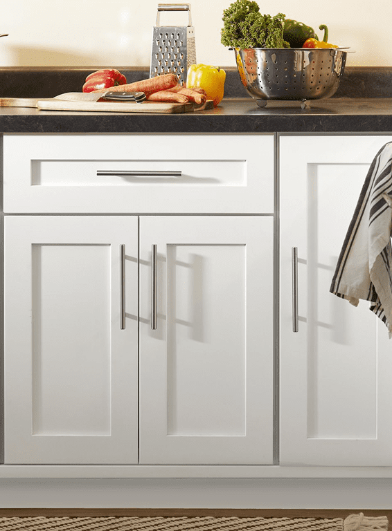 Close-up of white kitchen cabinets with silver handles.