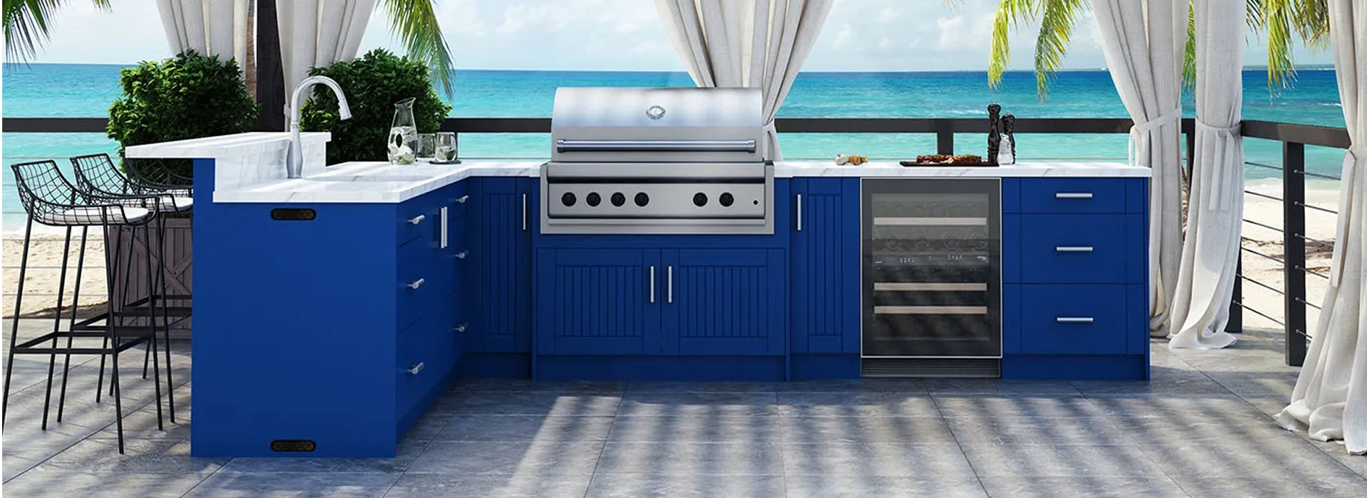 Outdoor kitchen with a stainless steel grill and ocean view.