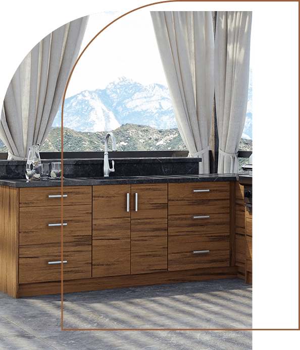 A full shot of a kitchen sink with brown cabinet drawers against a mountain backdrop.